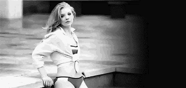 a black and white photo of a woman in a bikini and a shirt .
