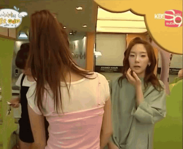 a woman standing in front of a sign that says kbs on it