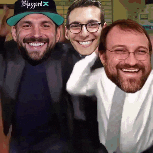 a man wearing a hat that says blizzard x smiles with two other men