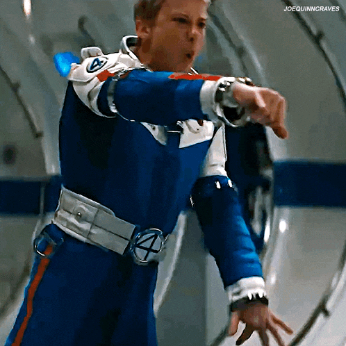 a man in a blue and white superhero suit is pointing at something