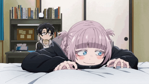 a boy and a girl are laying on a bed and the girl has a cell phone on her head