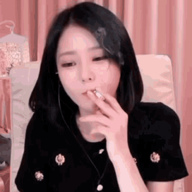 a woman is smoking a cigarette while sitting on a chair .