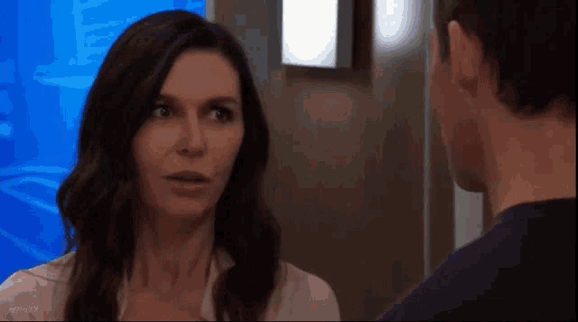 a man and a woman are standing next to each other and looking at each other in a room .