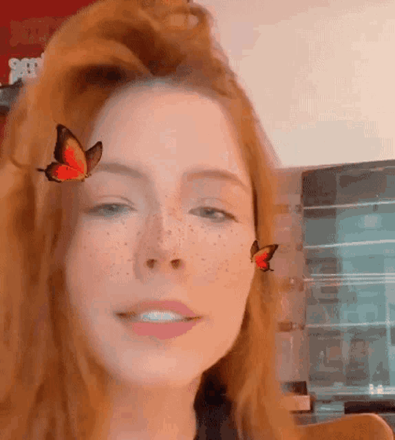 a close up of a woman 's face with two butterflies on her face