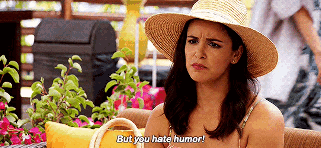 a woman in a straw hat is sitting on a couch and saying but you hate humor .