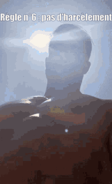 a man without a shirt is standing in front of a blue sky with the sun shining on his chest .