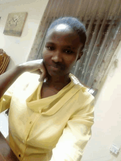 a woman in a yellow shirt has her hand on her face