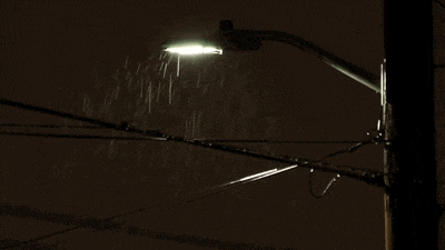 a street light shines brightly in the rain