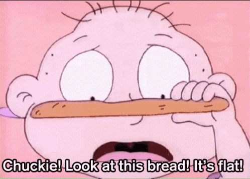 a cartoon character is holding a loaf of bread in his mouth and says chuckie look at this bread it 's flat