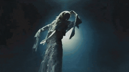 a woman with white hair is floating in the water .