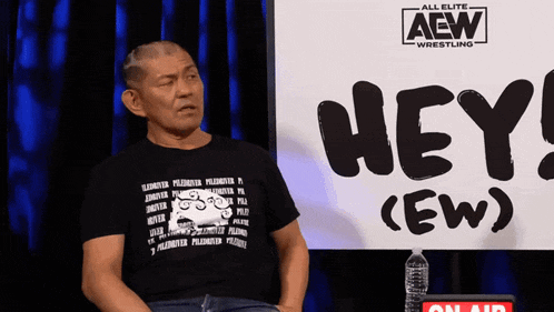 a man is sitting in front of a sign that says hey ( ew )