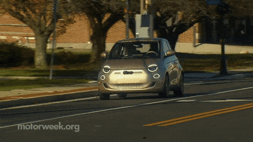 a small car is driving down a road with motorweek.org written on the bottom
