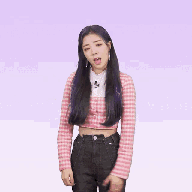 a woman with purple hair is wearing a pink plaid crop top and black jeans