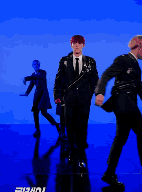 a man in a suit and tie is walking in front of a blue background with the letters ii and ii on it