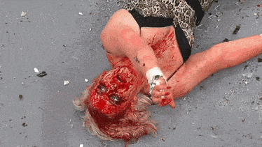 a woman in a leopard print top is laying on the ground with blood on her face
