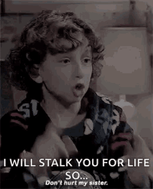 a young boy with curly hair is talking to another young boy .