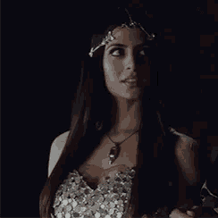 a woman wearing a necklace and a headband is smiling .