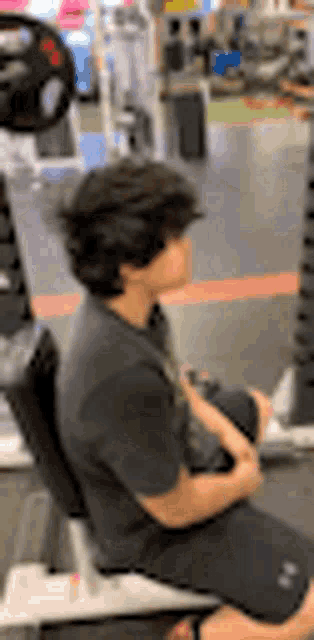 a person is sitting on a machine in a gym .