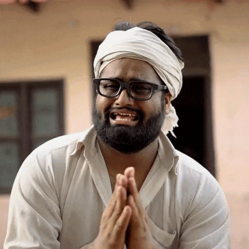 a man wearing glasses and a headband is praying