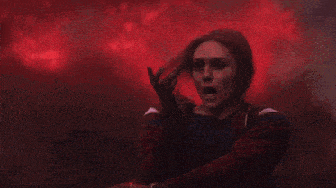 a close up of a person holding a red torch in a dark room .