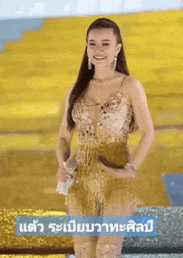 a woman in a gold dress stands in front of a sign that says ' a '
