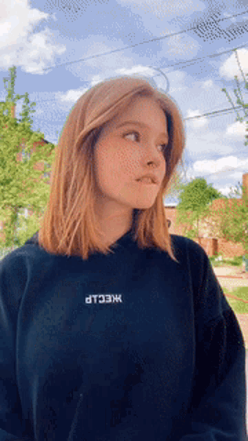 a girl wearing a black sweatshirt with the word kneecap on the front