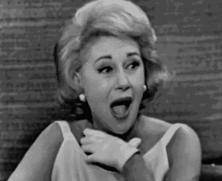 a black and white photo of a woman making a funny face .