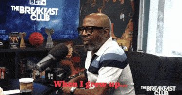 a man sitting in front of a microphone with the words " when i grew up " above him