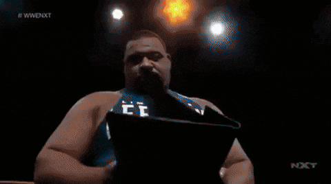 a man is holding a screen that says wwe nxt on it