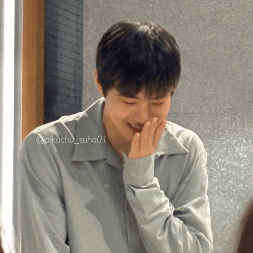 a close up of a man covering his mouth with his hand with the hashtag @pikachu_suhoo01