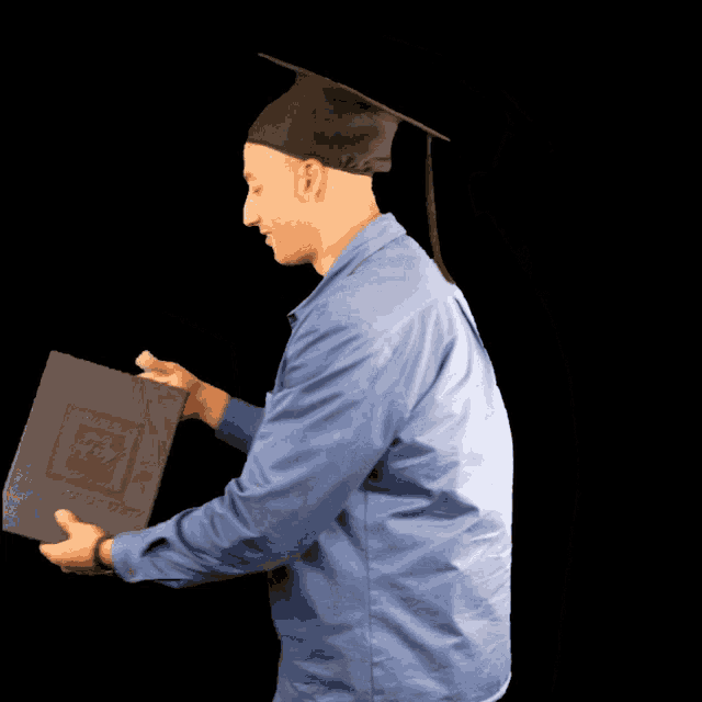 a man wearing a graduation cap and gown holds up a diploma