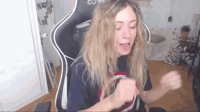 a woman is sitting in a chair with her tongue hanging out .