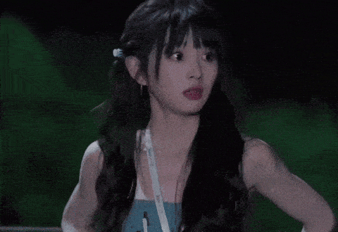 a woman with a lanyard around her neck is making a funny face with her hand