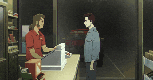 a man in a red shirt is talking to another man at a counter