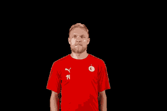 a man wearing a red shirt with the number 14 on the front