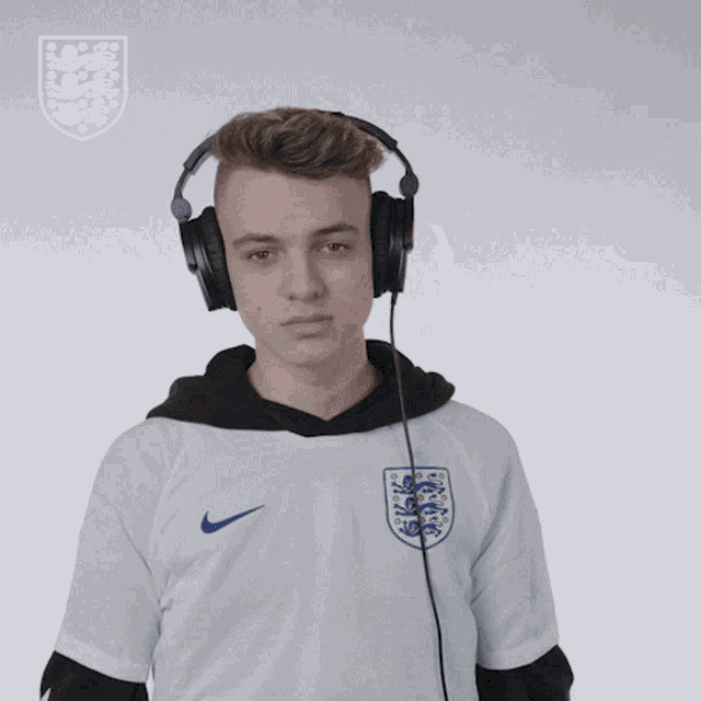 a man wearing headphones and a nike shirt with the england crest on it