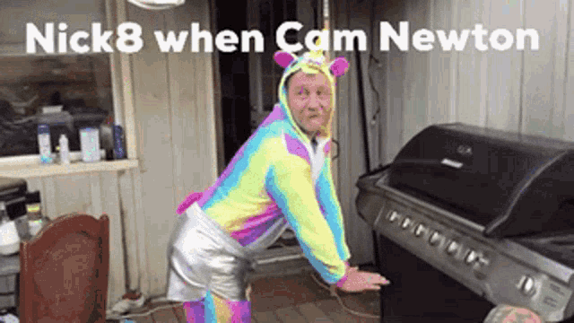 a man in a unicorn outfit is standing in front of a grill .