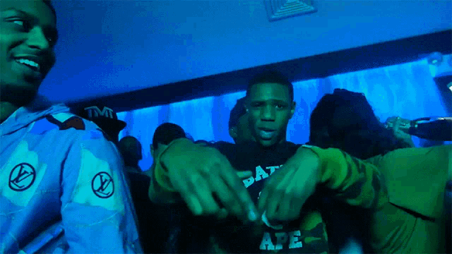 a man wearing a black shirt that says " ape " on it