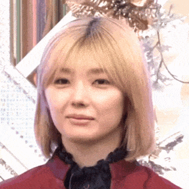 a woman with blonde hair is wearing a red shirt and a black scarf