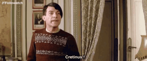 a man wearing a sweater says cretinus in a room