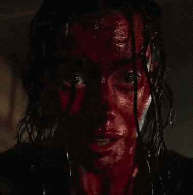 a close up of a woman 's face covered in blood .