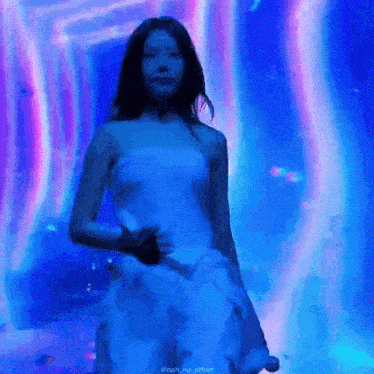 a woman in a white dress is standing on a stage in front of a blue background .