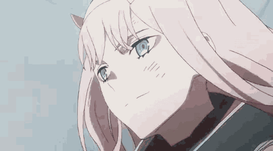 a close up of a girl 's face with pink hair and blue eyes .