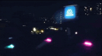 an aerial view of a city at night with a bridgestone logo in the foreground .