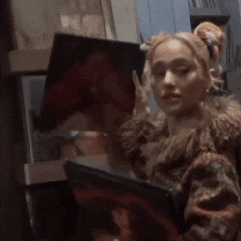 a woman in a fur coat is looking at a painting