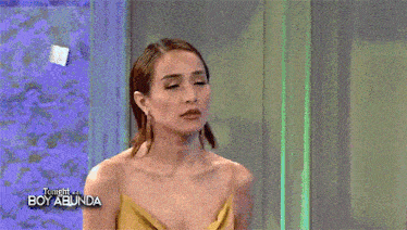 a woman is touching a man 's head on a tv show called boy abunda