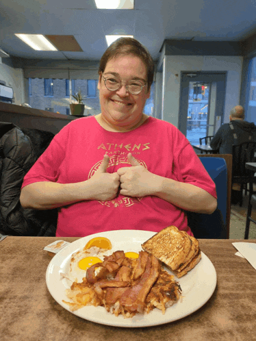 a woman wearing a pink shirt that says athens on it