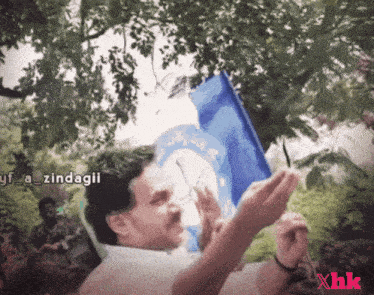a man holding a blue flag with a white circle on it