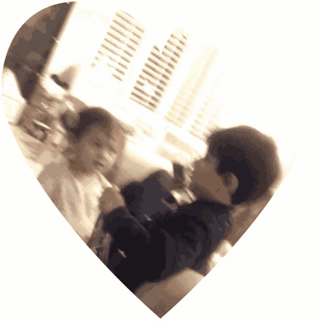 a boy and a girl are playing in a heart shaped mirror