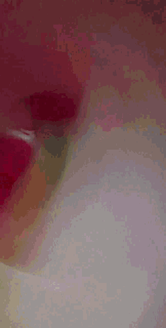 a close up of a person 's face with a pink shirt on